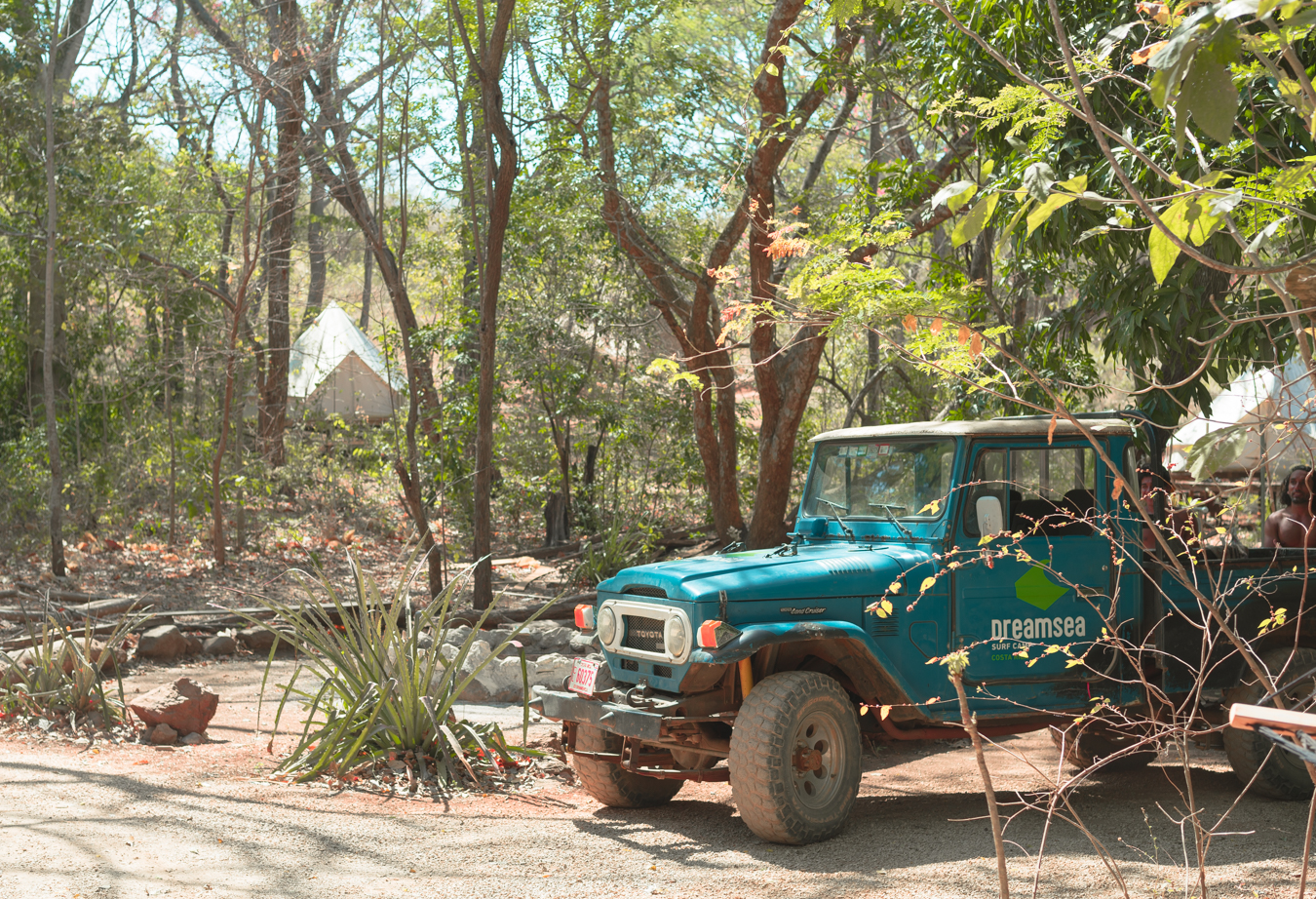 Dreamsea Costa Rica Surf Camp | backpacking, travel, hostel, surf, and yoga camp | Media Files | Lifestyle Image of Surf and Yoga Camp Resort | Dreamsea advertising vehicle in a wilderness view just outside of dreamsea surf camp with trees around it