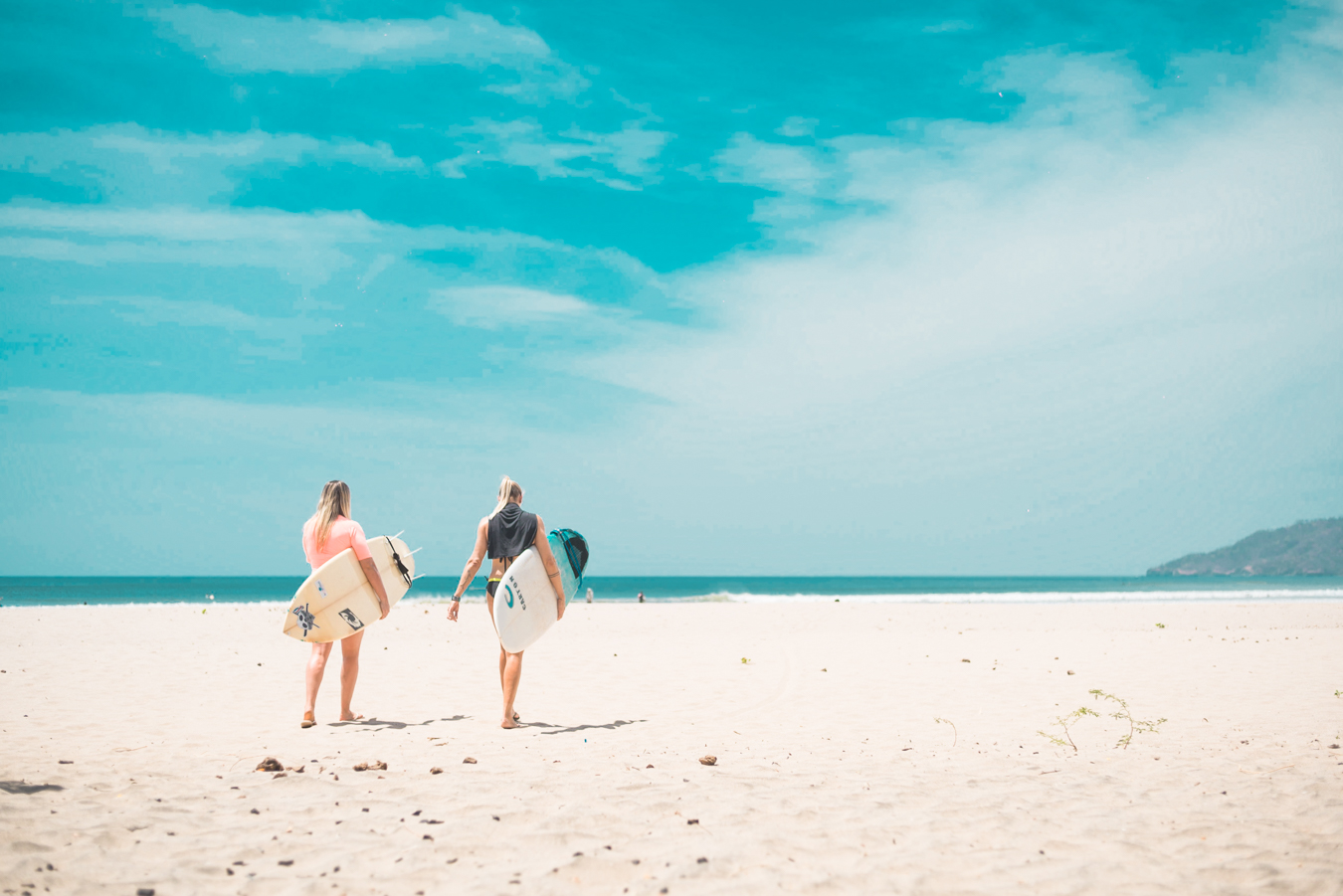 Dreamsea Costa Rica Surf Camp | backpacking, travel, hostel, surf, and yoga camp | Media Files | Lifestyle Image of Surf and Yoga Camp Resort | Image of 2 people walking on a beach with surfboards in their hands.