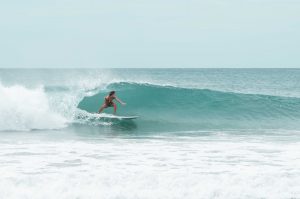 Dreamsea Costa Rica Surf Camp | backpacking, travel, hostel, surf, and yoga camp | Media Files | Lifestyle Image of Surf and Yoga Camp Resort | girl surfing under a wave in tamarindo costa rica