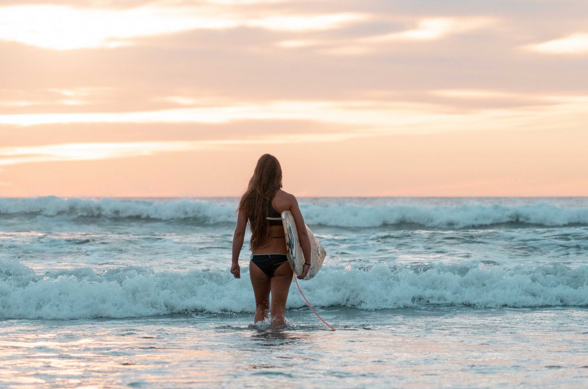 Dreamsea Costa Rica Surf Camp | backpacking, travel, hostel, surf, and yoga camp | Blog | volunteer | picture of a girl surfing having fun on beach at dreamsea costa rica surf camp in Tamarindo Costa Rica 8