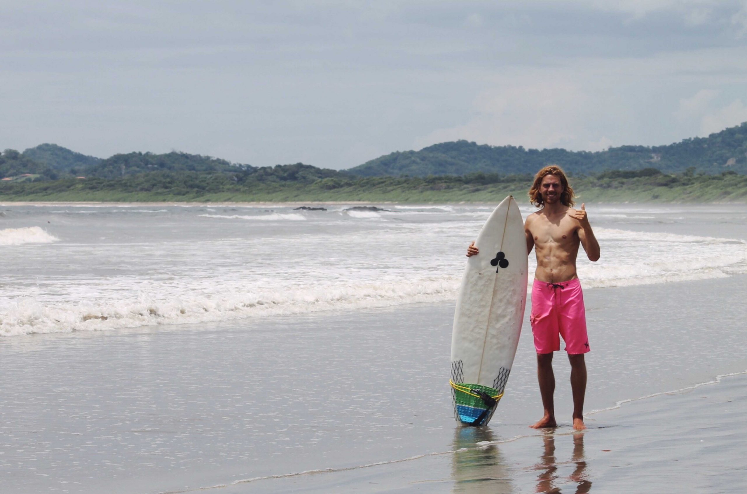 Dreamsea Costa Rica Surf Camp | backpacking, travel, hostel, surf, and yoga camp | Blog | picture of man holding a surf board