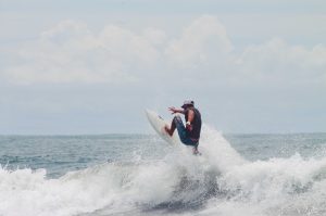 Dreamsea Costa Rica Surf Camp | backpacking, travel, hostel, surf, and yoga camp | Blog | picture of man in a hat on a surf board
