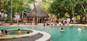 Dreamsea Costa Rica | Main Footer Background Image | Image of a group of people hanging around a pool and cabana
